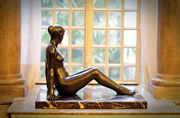 Escultura de bronce de mujer con ventana